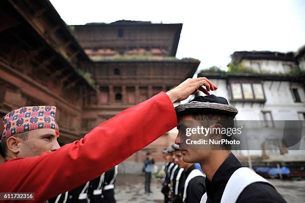 Nepalese Priest offering Red tika and holy flower to the member of Nepalese Army Personnel of Gurujuko Paltan after performing ritual puja during the...