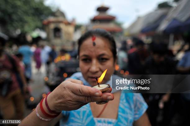 Nepalese devotees offering butter lamps infornt of Kaal Bhairab during the Gatasthapana first day of Biggest Hindu festival Dashain at Nasal Chowk,...