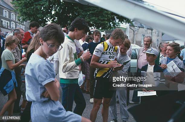 American cyclist Greg LeMond signs autographs at the Critérium de Château-Chinon road race, Château-Chinon, Nièvre, France, circa 1982.