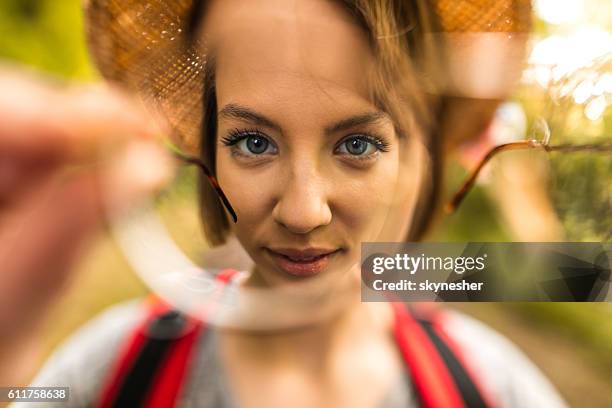 feche acima da mulher olhando para a câmera através de óculos. - olhando através - fotografias e filmes do acervo