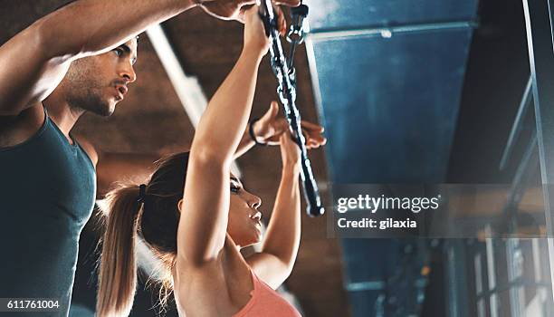 lat pull down exercise at gym. - coaching couple stock pictures, royalty-free photos & images