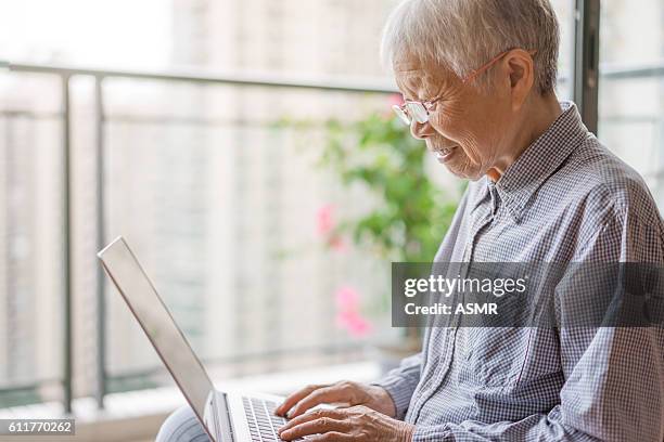 senior woman using a laptop - retiremen stock pictures, royalty-free photos & images