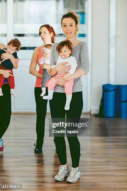 mothers exercising with their babies in a gym - baby studio stock pictures, royalty-free photos & images