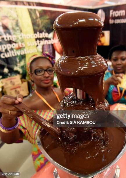 Visitors arrive to taste chocolate from a fountain a stand in Abidjan on October 1, 2016 during the national days of cocoa and chocolate. Ivory...