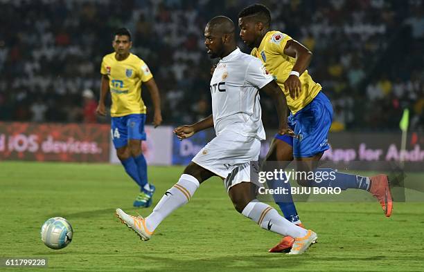 Northeast United FC's midfielder Koffi Ndri is challenged by Kerala Blasters FC's forward Antonio German as he controls the ball during the Indian...