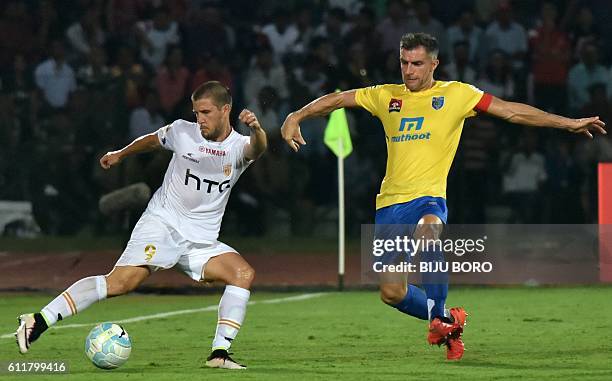 Northeast United FC's Emiliano Alfaro is challenged for the ball by Kerala Blasters FC's defender Aaron Hughes during the Indian Super League...