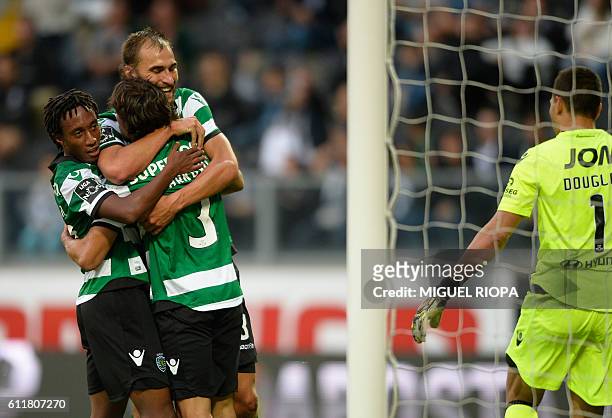 Sporting's Serbian forward Lazar Markovic celebrates with teammates forward Gelson Martins and Dutch forward Bas Dost after scoring a goal during the...