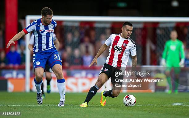 Brentford's Nico Yennaris holds off the challenge from Wigan Athletic's Yanic Wildschut during the Sky Bet Championship match between Brentford and...