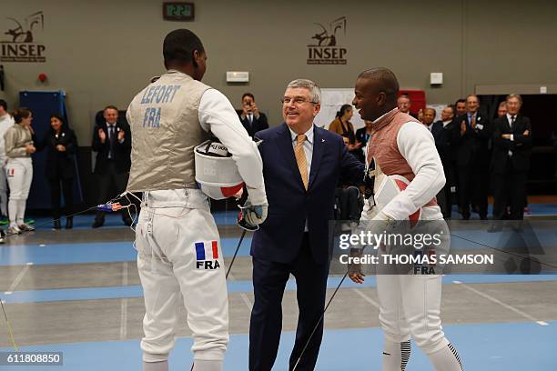 French foil fencers Enzo Lefort and Jean-Paul Tony Helissey speak with former fencer and International Olympic Committee president Thomas Bach at the...