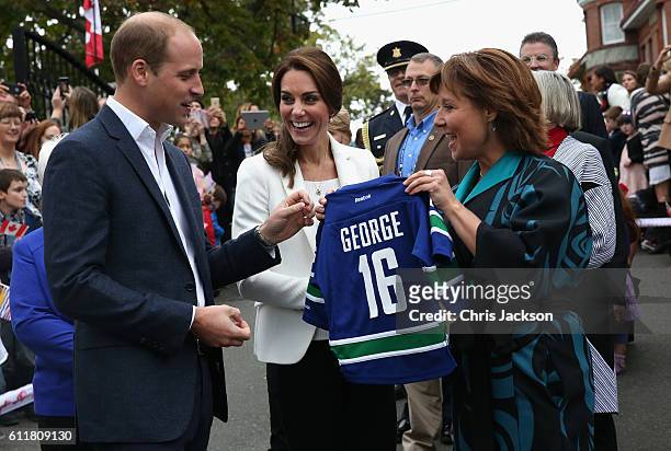 Catherine, Duchess of Cambridge and Prince William Duke of Cambridge are presented with personalised sports shirts for Prince George and Princess...