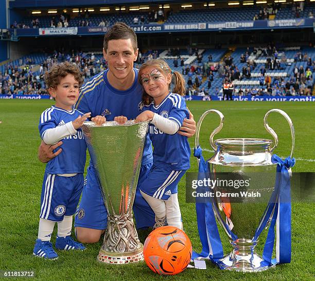 Chelsea's Fernando Torres with his children Nora and Leo pose with the Champions League and Europa League trophy