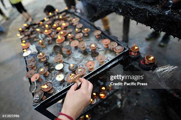 Nepalese devotees offering butter lamps infornt of Kaal Bhairab during the Gatasthapana first day of Biggest Hindu festival Dashain at Nasal Chowk,...