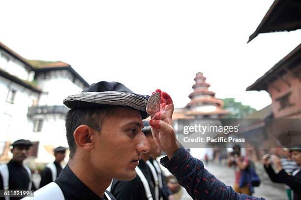 Nepalese Priest offering Red tika and holy flower to the member of Nepalese Army Personnel of Gurujuko Paltan after performing ritual puja during the...