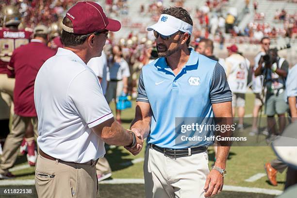Head coach of the Florida State Seminoles Jimbo Fisher talks to the head coach of the North Carolina Tar Heels Larry Fedora before the game at Doak...