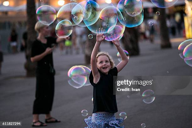 toddler girl catching bubbles joyfully outdoor - bubble wand ストックフォトと画像