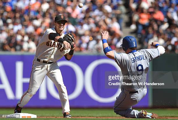 Joe Panik of the San Francisco Giants completes the double-play throwing over the top of Yasmani Grandal of the Los Angeles Dodgers in the top of the...