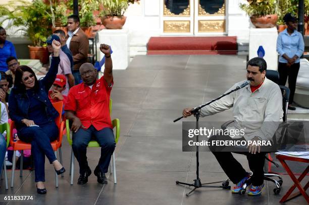 Venezuelan President Nicolas Maduro speaks while Venezuelan First lady Cilia Flores and Vice-President Aristobulo Isturis raise their fists during...