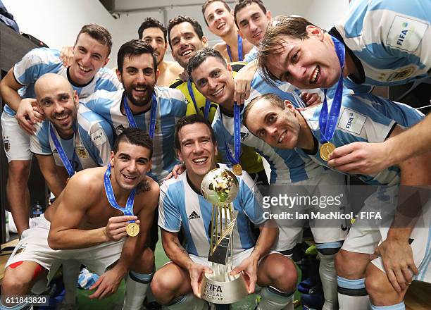 Fernando Wilhelm of Argentina poses with the winners trophy during the FIFA Futsal World Cup Final match between Russia and Argentina at the Coliseo...