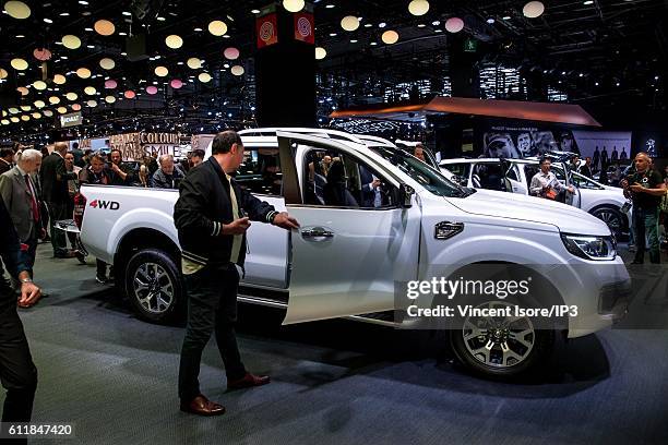 Visitors test the latest Renault Alaskan car during the press preview of the Paris Motor Show at Paris Expo Porte de Versailles on September 29, 2016...