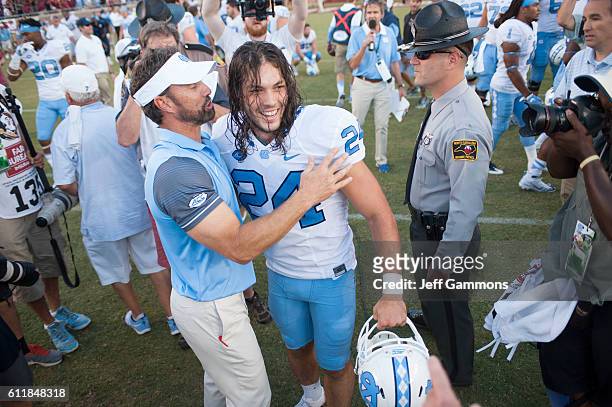 Nick Weiler of the North Carolina Tar Heels celebrates with the Tar Heels head coach Larry Fedora after their win over the Florida State Seminoles at...