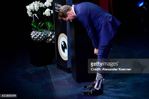 Moderator Steven Gaetjen shows his socks on stage during the Award Night Ceremony during the 12th Zurich Film Festival on October 1, 2016 in Zurich,...