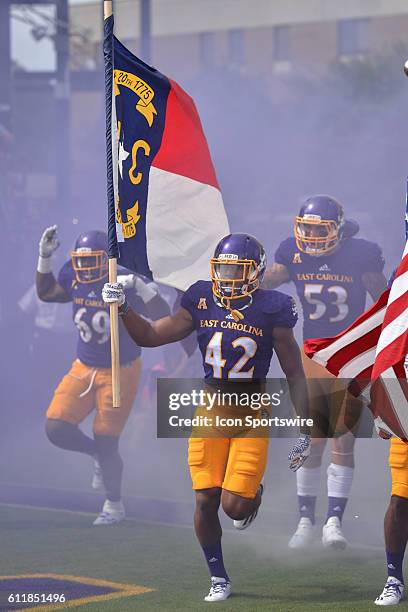 East Carolina Pirates defensive back Devon Sutton carries out the North Carolina flag before a game between the East Carolina Pirates and the Central...