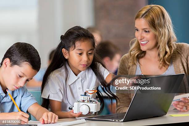 allegro insegnante di scuola stem elementare aiuta gli studenti con l'assistenza - educazione di scuola privata foto e immagini stock