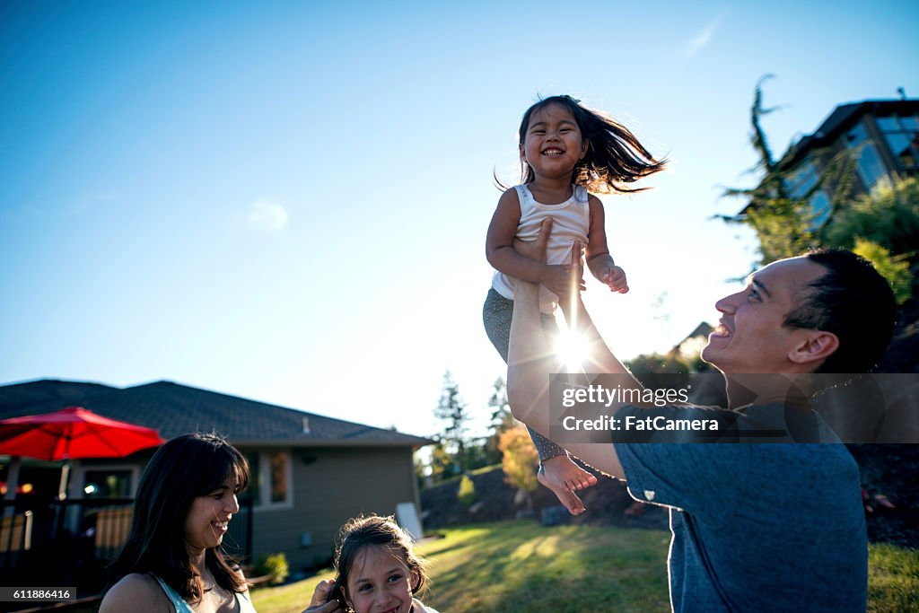 Ethnic father holding his daughter in the air