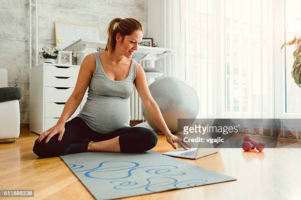 young pregnant woman exercises at home. - prenatal care stockfoto's en -beelden