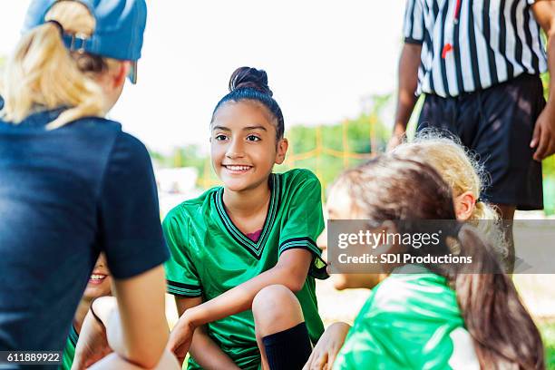 weibliche trainerin gibt pep-talk mit ihrem team - nachwuchssportler auswahl sportveranstaltung stock-fotos und bilder