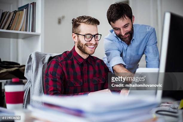 two happy men in the office - happy office workers stockfoto's en -beelden