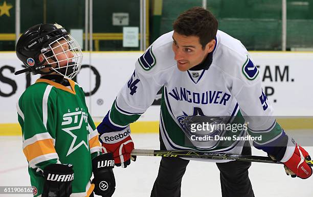 Alumni Aaron Volpatti gives direction to a youth hockey player in the on ice clinic at the Pat Duke Memorial Arena during Day 2 of NHL Kraft...