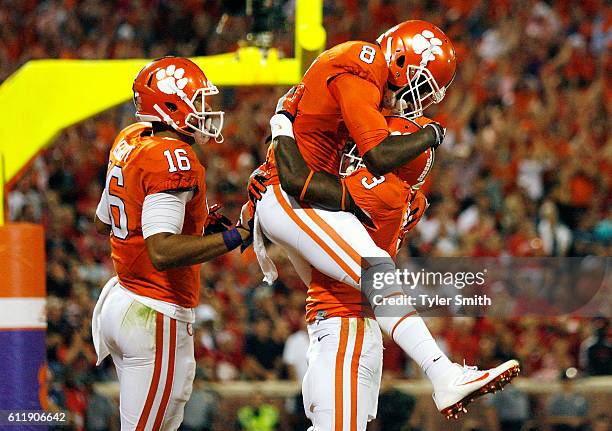 Deon Cain of the Clemson Tigers is congratulated by his teammates Jordan Leggett and Artavis Scott after scoring a second quarter touchdown reception...