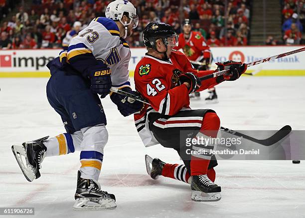 Kenny Agostino of the St. Louis Blues gets called for hooking against Gustav Forsling of the Chicago Blackhawks during a preseason game at the United...