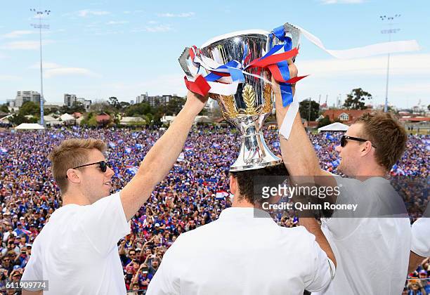 Lachie Hunter, Tom Liberatore and Jake Stringer of the Bulldogs show the trophy to the crowd during the Western Bulldogs AFL Grand Final celebrations...