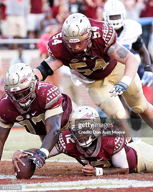 Quarterback Deondre Francois Tackle Roderick Johnson and Center Alec Eberie of the Florida State Seminoles dive to recover a loose ball in the end...