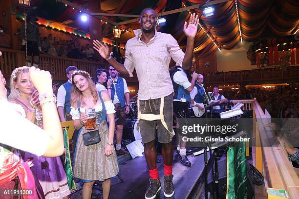 Usain Bolt, sprinter, ninefold olympic champion and elevenfold world champion sings and performs on stage with the orchestra during the Oktoberfest...