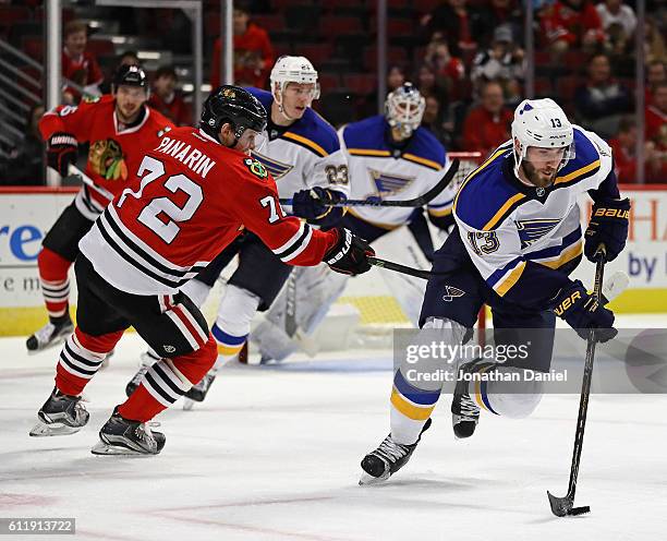 Landon Ferraro of the St. Louis Blues breaks up the ice past Artemi Panarin of the Chicago Blackhawks during a preseason game at the United Center on...