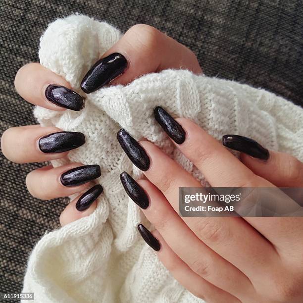 close-up of hand with black nail varnish holding wool - esmalte de uñas negro fotografías e imágenes de stock