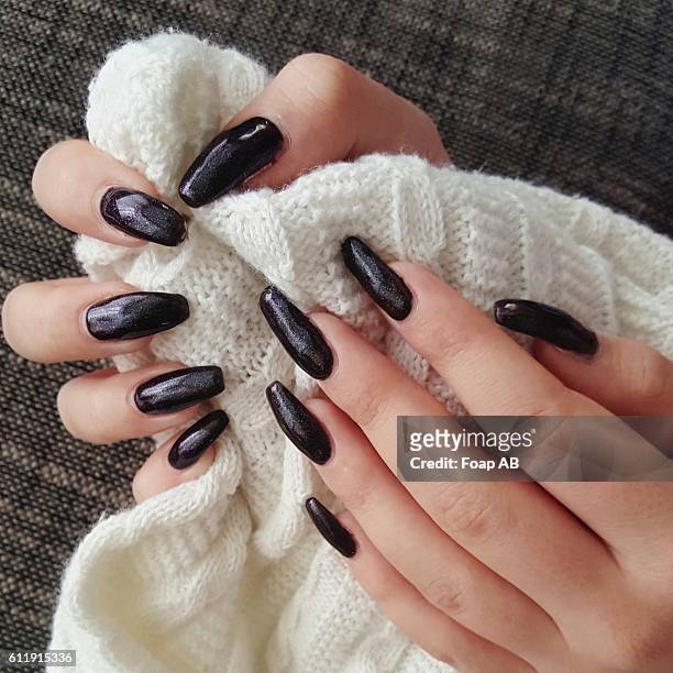 close-up of hand with black nail varnish holding wool - black nail polish stock pictures, royalty-free photos & images