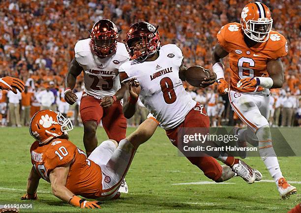 Lamar Jackson of the Louisville Cardinals avoids the tackle of Ben Boulware and Dorian O'Daniel during the third quarter of the Clemson Tigers at...