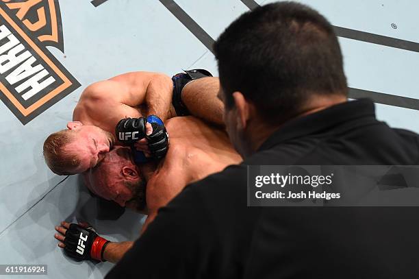 Zak Ottow attempts to submit Joshua Burkman in their welterweight bout as referee Jon McCarthy views during the UFC Fight Night event at the Moda...