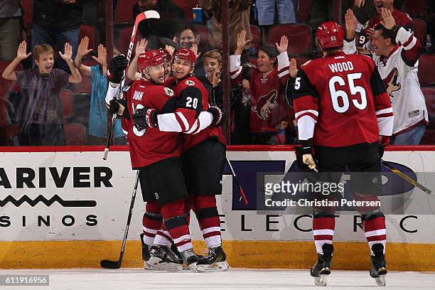 Dylan Strome of the Arizona Coyotes celebrates with Shane Doan and Kyle Wood after Strome scored a third period goal against Anaheim Ducks during the...