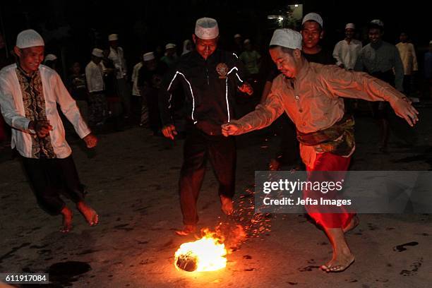 Indonesian Muslims seen playing a soccer game using a fireball made from a coconut from a palm tree soaked in kerosene as they take part in the...