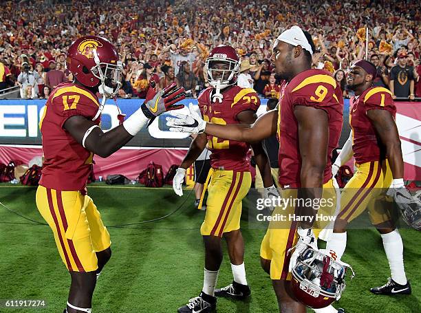 Wide receiver JuJu Smith-Schuster of the USC Trojans celebrates his third touchdown of the game with wide receiver Josh Imatorbhebhe, running back...