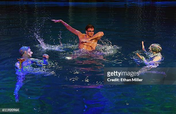 Olympian Ryan Lochte performs in the pool at the "O" theater with "O by Cirque du Soleil" performers Nayara Figueira and Christina Jones as Lochte...