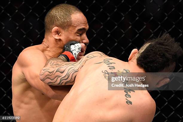 John Lineker of Brazil punches John Dodson in their bantamweight bout during the UFC Fight Night event at the Moda Center on October 1, 2016 in...