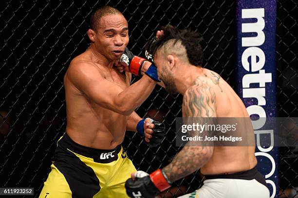 John Lineker of Brazil punches John Dodson in their bantamweight bout during the UFC Fight Night event at the Moda Center on October 1, 2016 in...