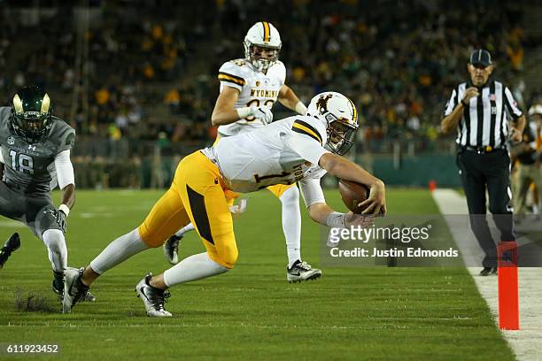 Quarterback Josh Allen of the Wyoming Cowboys dives into the end zone past the defense of defensive back Braylin Scott of the Colorado State Rams on...