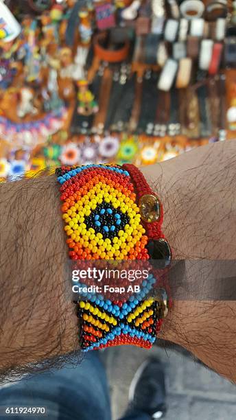 colorful mexican bracelet on man's hand - beads stock pictures, royalty-free photos & images